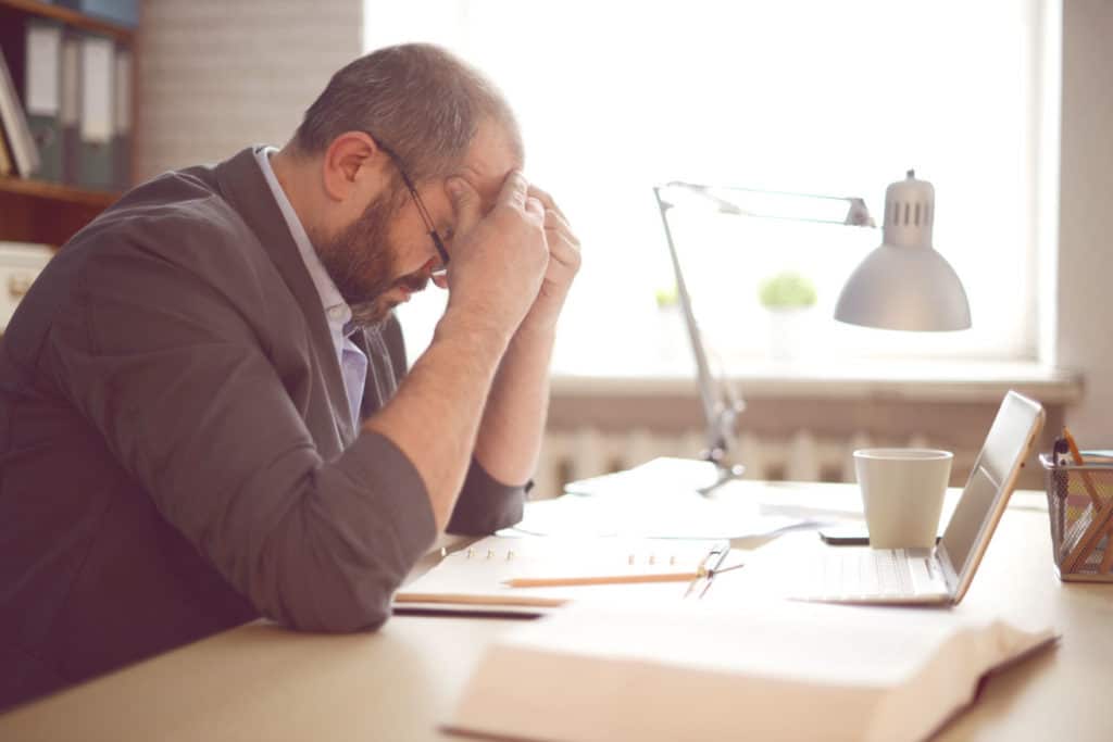 a man looking frustrated with his head in his hands