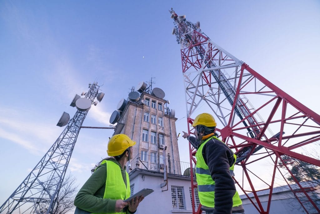 two workers pointing at broadband towers