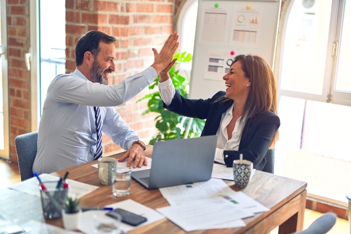 A man and a woman celebrating a work success